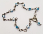 Pulseira produzida em prata de lei, com miçangas em vidro opalinado representando Olho grego, e simbolos do infinito, comprimento aberto:17,5cm.