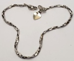 Pulseira produzida em prata de lei, estilizado design, com pingente em formato de coração, comprimento aberto:18,5cm.