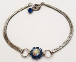 Pulseira produzida em prata de lei corrente modelo achatada, com representação de flor em pedras azuis, comprimento aberto:17cm.