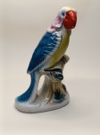  Estatueta Decorativa de Papagaio  Cerâmica ColoridaPeça artística e vibrante em cerâmica esmaltada, representando um papagaio multicolorido empoleirado sobre um galho. Acabamento brilhante e pintura detalhada, ideal para decoração de interiores ou coleção de aves decorativas.