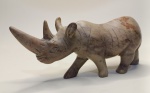 Escultura Decorativa de Rinoceronte  Arte em Pedra PolidaPeça artística e sofisticada esculpida em material semelhante à pedra, com acabamento polido e detalhes realistas. Representa um rinoceronte com traços anatômicos bem definidos, incluindo textura gravada que imita a pele do animal e expressão facial marcante.