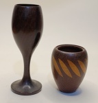 Conjunto Artesanal de Madeira  Cálice Decorativo e Vaso com Detalhes GeométricosTransforme sua decoração com este conjunto exclusivo de peças entalhadas em madeira de alta qualidade. O cálice apresenta design refinado e base robusta, ideal como item decorativo ou para composições rústicas-chiques. O vaso complementa o conjunto com detalhes geométricos em madeira clara, criando um contraste visual sofisticado e contemporâneo.