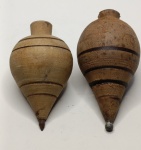 Piões Rústicos de Madeira  Par Tradicional  Colecionáveis e DecorativosReviva a diversão das brincadeiras clássicas com este par de piões artesanais em madeira maciça. Com formato cônico e sulcos horizontais entalhados, cada peça apresenta variações de cor e textura, evidenciando o charme do trabalho manual e a beleza natural da madeira.