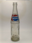 Garrafa Vintage Pepsi  Ícone dos Anos 80/90 Para os apaixonados por nostalgia, esta garrafa original da Pepsi é uma verdadeira viagem no tempo! Fabricada entre os anos 1980 e 1990, ela vem em vidro transparente com o emblemático logotipo tricolor em vermelho, branco e azul, além da inscrição Indústria Brasileira, reforçando sua autenticidade.