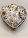 Caixa Coração em Porcelana  Pintura Floral com Acabamento Dourado Um mimo cheio de charme! Esta delicada caixa em formato de coração é feita em porcelana branca e decorada com um elaborado padrão floral multicolorido, em vermelho, azul, amarelo, verde e preto. O acabamento com friso dourado dá um toque refinado e retrô, ideal para decoração ou uso como porta-joias.