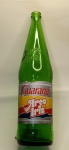 Garrafa Vintage  Guaraná Arco Íris  1 Litro  Circulação: Década de 1980Peça rara e cheia de personalidade, esta garrafa de vidro verde do Guaraná Arco Íris foi amplamente comercializada durante a década de 1980, período em que a marca se destacou no mercado regional com sua identidade vibrante e visual marcante.