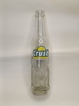 Garrafa Vintage  Crush  290 ml  Circulação: Década de 1980Este modelo clássico da Crush, com capacidade de 290 ml e vidro transparente, foi amplamente comercializado no Brasil durante a década de 1980, especialmente entre os anos 1985 e 1990. A garrafa apresenta o tradicional rótulo com logotipo verde e ilustração de fatia de limão, além de sulcos verticais na base  elementos típicos da estética retrô da época.