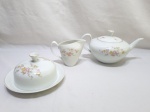 Jogo de servir chá, café com 3 peças em porcelana Renner floral com friso ouro. Composto de bule, leiteira e manteigueira. Medindo o bule 11cm de altura.