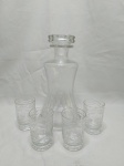 Lote de garrafa licoreira e 4 copos de aperitivo em demicristal trabalhado. Medindo 13cm de base x 24,5cm de altura total.