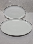 Par de travessas redondas rasas em porcelana Steatita com friso prata. Medindo a maior 42,5cm x 26cm.