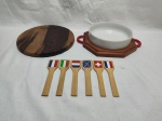 Lote de petisqueira redonda em porcelana, suporte em madeira, tábua de cortes, etc. Medindo a travessa em porcelana 16,5cm x 5cm de altura.