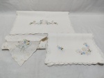 Jogo de tecidos bordados, composto de caminhos de mesa, jogos americano, guardanapos. Medindo o maior 90cm x 40cm. Peças com marcas de guardado.