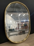 Espelho facetado oval com moldura dourada, apresenta marcas do tempo, med. = 60x42cm