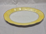 Travessa oval em porcelana Rio Branco, friso ouro com barra amarela. Medindo 39cm x 25cm. Com desgaste na douração.