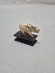 Pequeno enfeite na forma de elefante em marfim com base em madeira. Medindo 5cm x 2,5cm de base x 4,5cm de altura total.
