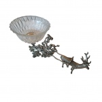 Centro de mesa representando trenó puxado por cervo e guarnição lavrada e repuxada com anjos e acantos em metal prateado, a carruagem em cristal, Com. 42,  Larg. 14, Alt. 9 cm.