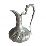 Ânfora bojuda muito elegante em estanho, corpo gomado e cinzelado, asa recurva representando cabeça de animal, Alt. 27, Diam. 20 cm.
