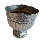Centro de mesa representando taça em metal prateada lavrado em gomos e bordas com folhagens, apoiado em base circular, Alt. 7, Diam. 16 cm.
