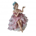 Escultório em porcelana policromada anos 50, representando dama em suntuoso vestido com rosas  sobre fundo branco, falta o espelho de mão e os dedinhos de uma das mãos está quebrado, 26 x 16, Alt. 24 cm.