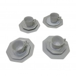 Quatro xícaras para chá, 4 pires (um adaptado) e 4 pratos para sobremesa em porcelana Germer com bordas oitavadas.