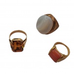 Três anéis em metal dourado com pedras: opalina, topázio e coral, aros, 25, 19 e 15.