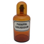 Grande pote de farmácia de vidro âmbar com seu copo. Apresenta rótulo com a inscrição: PARAFFIN SUBLIQUIDUM. 40 x 19 cm (MT). 13 cm (copo).