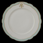 IMPÉRIO BRASILEIRO. BARÃO DE GUARATIBA (Atribuido) - Prato raso de porcelana francesa. Pertencente ao Serviço do Barão de Guaratiba (Joaquim José Ferreira). Borda ondulada com friso na cor verde e dourada. Iniciais entrelaçadas na borda. No verso resquícios da manufatura J. Gauvain Paris, R Houteville, 53. 24 cm.