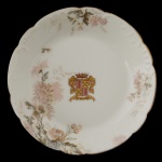IMPÉRIO BRASILEIRO. BARÃO DO PORTO FELIZ - Haviland Limoges. H&C France - Covilhete em porcelana francesa pertencente ao Serviço do Barão de Porto Feliz (Cândido José de Campos Ferraz). Apresenta formato circular e recortado. Fundo de superfície branca com decoração floral. Brasão de Armas no centro. No fundo marca da manufatura. 4 x 18 cm. Cândido José de Campos Ferraz, primeiro e único Barão de Porto Feliz, (Campinas, 25 de outubro de 1830 Rio Claro, 12 de dezembro de 1880), foi fazendeiro e político brasileiro, tendo sido líder do Partido Conservador na região de Limeira, São Paulo. Fundou a colônia agrícola de Boa Vista. Em 6 de novembro de 1867, o imperador D. Pedro II concedeu o título de Barão de Porto Feliz a Cândido José de Campos Ferraz. A entrega da distinção nobiliárquica ocorreu em 6 de fevereiro de 1868, data em que recebeu oficialmente o título das mãos do monarca e em que seu brasão foi registrado junto ao Cartório da Nobreza da Província de São Paulo. 18.5 cm