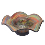 Centro de mesa circular em cristal de Murano com laterais com movimentos e onduladas, ornadas por listas policromadas, centralizando fundo mesclado. Decoração externa com arabescos e motivos abstratos. 16 x 38 cm.