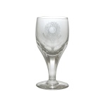 ESTADOS UNIDOS DO BRASIL 15 de Novembro de 1889 - Copo em cristal lapidado, com bojo cônico realçado por facetas dedão. Apresenta à frente gravação com o brasão de armas dos Estados Unidos do Brazil, tendo estrela de 5 pontas e data de 15 de Novembro de 1889. Haste facetada apoiada em base circular. 10 cm.