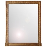 Espelho de parede retangular, bordado por moldura em madeira patinada a ouro. Apresenta frisos geométricos e florais, rematados por florões nas quinas. Trave inferior lisa. No verso etiqueta da Casa Barcelá Móveis & Decoração. 75 x 95 cm (MI). 91 x 110 cm (MT).