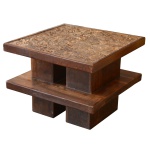 Mesa em madeira, construída com 2 plateaux quadrangulares superpostos, bordados por frisos lisos e reunidos por par de montantes retangulares. Base repetindo formato e tamanho dos referidos montantes. Tampo em cortiça prensada. 54 x 70 x 70 cm.