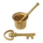 Lote constando de 3 peças em metal amarelo polido, sendo: pilão (7 x 9 cm) e socador (17 cm). Acompanha uma chave.