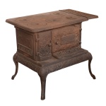 Antigo fogão a lenha em ferro fundido, de formato retangular, moldado e decorado com volutas e estilizações. Placa superior com 5 bocas e aba lateral, apoiada em corpo reto com 2 portas. Base saliente com saia lavrada, apoiada em pernas recurvas com pés revirados. 74 x 94 x 56 cm. PEÇA PESADA. Esta disponivel para ser visto. Este lote encontra-se na Granja Julieta, SP. Retirada com agendamento antecipado em nosso Escritório do Leilão  11.5044.1228.