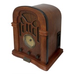 USA Classic Colletion Editios. Radio de mesa AM/FM com caixa retangular em madeira nobre com frontão arqueado. Frente com colunatas laterais centralizando tela da caixa de som, mostrador circular de frequências e botões de ajuste. Base saliente apresentando placa do fabricante à frente. Modelo retro dos anos 1930-1940. 36 x 25 x 23 cm.