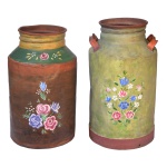 Conjunto de 2 galões cilíndricos para leite em folha de flandres, pintados em policromia floral sobre fundos lisos. Bojos retos, sendo o maior com alças laterais. Gargalos retraídos com tampas planas.. 58 x 34 cm e 64 x 36 cm. Sinais de uso e do tempo.