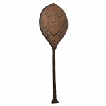 Adaga indígena em madeira, de formato circular com cabo reto rematado por pega triangular. Apresenta adornos triangulares vermelhos e sulcos escavados pretos. 125 x 38 x 2 cm.