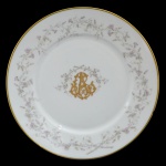 CRISTOVÃO RODRIGUES DE ANDRADE - Prato circular e raso em porcelana branca, realçado por borda com filete dourado pertencente ao Serviço de Cristóvão Rodrigues de Andrade. Margem ornada por guirlanda florida em grisaille. Centro ornamentado por monograma dourado sob ramalhete. Filho do Barão de Piabanha e neto da Baronesa de Campo Belo. Exemplares do mesmo serviço expostos no Museu da Casa da Hera, em Vassouras, Rio de Janeiro. Foi Capitão de Milícias e Coronel da Imperial Guarda de Honra do Imperador Pedro I. Apresenta alguns pequenos bicados no verso.