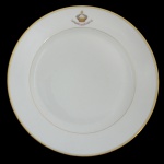 CORONEL ANIBAL DE MENDONÇA - Prato circular em porcelana francesa, pertencente ao Serviço do Coronel Anibal de Mendonça.  Fundo de superficie branca com frisos dourados, apresentando iniciais entrelaçadas na borda. 23 cm.