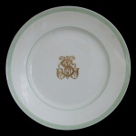 IMPÉRIO BRASILEIRO. BARONESA LEOPOLDINA - FAZENDA SÃO MARTINHO - Prato raso em porcelana francesa da manufatura de Limoges, monogramado. Pertenceu ao Serviço da Baronesa Leopoldina da Fazenda São Martinho, com marca do importador: Casa Cypriano Rio de Janeiro. Século XIX / XX. 20 cm.