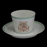 IMPÉRIO BRASILEIRO. BARONESA LEOPOLDINA - Xícara para chá com seu pires em porcelana francesa da manufatura de Limoges, monogramado. Pertenceu ao Serviço da Baronesa Leopoldina da Fazenda São Martinho, com marca do importador: Casa Cypriano Rio de Janeiro. Século XIX / XX. 6 x 8 cm (xícara).14 cm (pires).