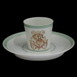 IMPÉRIO BRASILEIRO. BARONESA LEOPOLDINA - Xícara para café com pires em porcelana francesa da manufatura de Limoges, monogramado. Pertenceu ao Serviço da Baronesa Leopoldina da Fazenda São Martinho, com marca do importador: Casa Cypriano Rio de Janeiro. Século XIX / XX. 5 x 6 cm (xícara). 14 cm (pires).