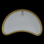 IMPÉRIO BRASILEIRO. BARÃO DE VASCONCELOS - Covilhete na forma de meia lua de porcelana francesa de manufatura de Limoges. Pertencente ao Serviço Barão de Vasconcelos (José Smith de Vasconcellos). Corpo com filetados a ouro e reserva com as iniciais SV encimado por uma coroa de visconde. Marca de manufatura Limoges, France, W.G. & Cie. ao fundo. Século XIX. 22 cm. Peça do mesmo serviço reproduzida à pág. 343 no Livro Louça da Aristocracia do Brasil, por Jenny Dreyfus.22 x 14 cm.