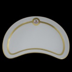 MINTONS, ENGLAND - Covilhete na forma de meia lua em porcelana inglesa. Superfície branca e borda com friso dourado, apresentando reserva com brasão inglês. Marcas da manufatura Mintons, England e do fabricante Tate and Oglesbt Ldt Hull. 21 x 14 cm.