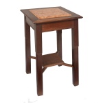 Pequena mesa de apoio em madeira nobre com tampo quadrangular liso, encimado por placa de mesmo formato em mármore mesclado bege e marrom. Saia reta realçada por filetes. Pernas retilíneas rematadas por canelados, sustentando pequena prateleira à meia altura. Sinais de uso. 80 x 45 x 45 cm.