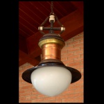 THOMSON-NY-USA - Luminária americana de teto, com bojo cilíndrico em cobre vermelho, sustentando chapéu circular preto centralizando cúpula piriforme em vidro leitoso. Parte superior com coroa dourada encimada por suporte em cruz e corrente. Fabricante: THOMSON Enclosed Arc Lamp - Electric Co. Completo. Possui o suporte da parte de cima original. 42 x 35 cm,