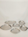 BAIXELA EM INOX LUZALITE COM 6 PEÇAS, SENDO 2 TRAVESSAS REDONDAS COM ALÇAS E 4 TRAVESSAS OVAIS EM DIFERENTES TAMANHOS, APRESENTAM MARCAS DO TEMPO E AMASSADOS. MEDIDA: MAIOR TRAVESSA OVAL 47,5 CM DE COMPRIMENTO X 20,5 CM DE LARGURA, MENOR TRAVESSA 26,5 CM X 16 CM