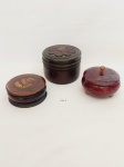 3 CAIXAS PORTA JÓIAS DE MADEIRA, EM 3 MODELOS E TAMANHOS DISTINTOS, SENDO UMA COM TAMPA COM ENTALHE DE FLOR EM RELEVO APRESENTA MARCAS DO TEMPO, UMA COM DETALHE DE FLOR TAMPA E UMA COM ACABAMENTO LAQUEADO EM TOM VINHO E 3 PÉS DE APOIO. MEDIDA: MAIOR 9 CM DE ALTURA COM TAMPA X 11 CM D, MENOR 4,5 CM DE ALTURA COM TAMPA X 9 CM D