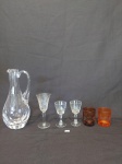 jOGO  COMPOSTO POR 1 JARRA EM  CRISTAL  TRANSLUCIDO APRESENTA BATIDO, NA ALÇA   E 3 TAÇAS DE APERITIVO EM CRISTAL E 2 COPOS PARA APERITIVO EM VIDRO LAPIDADO PINTADO. MEDIDA: MAIOR JARRA 4 CM X 3 CM X 24 CM DE ALTURA, MENOR COPO DE APERITIVO 5,5 CM D X 6,5 CM DE ALTURA