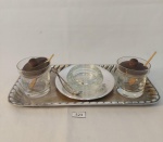 LOTE COMPOSTO POR 1 BANDEJA EM PRATA MARCADO ROBERTO SIMÕES, 1 SALEIRO,SEM TAMPA EM VIDRO E PRATA COM COLHER COM DETALHE DE PEDRA,  2   SALEIROS  EM VIDRO COM TAMPA EM MADEIRA. MEDIDA: BANDEJA 23 CM X 12 CM DE LARGURA, AÇUCAREIRO COM TAMPA 5 CM DE ALTURA X 5 CM D,  SEM TAMAPA 4,5 CM D X 3 CM DE ALTURA COM O 10,5 CM D, COLHER 8,5 CM